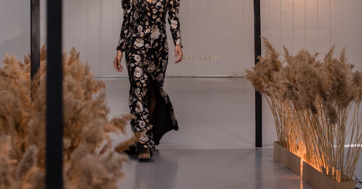 A model walks the runway in a floral long dress at a fashion show