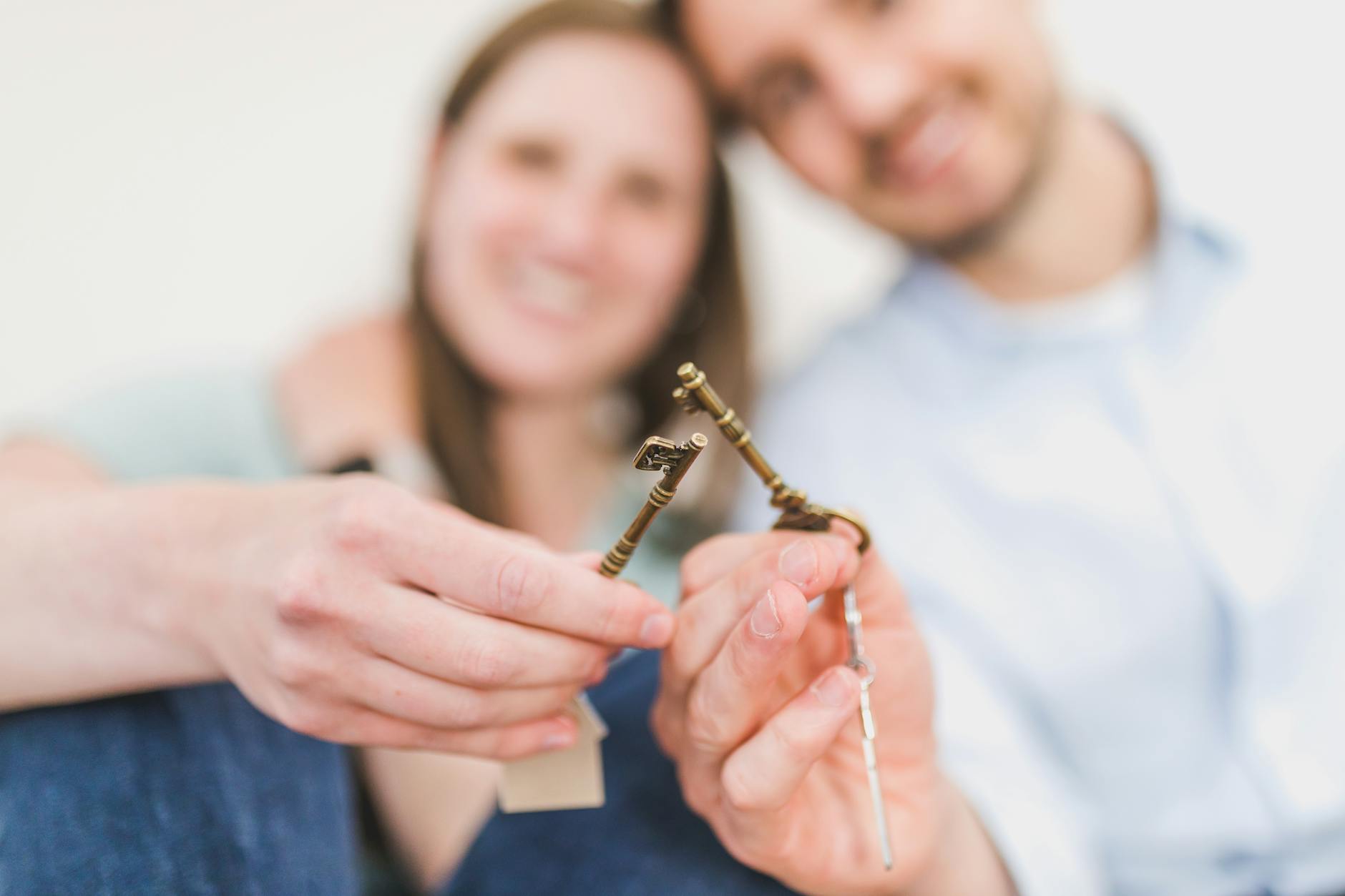 Couple holding house keys after buying their first home together