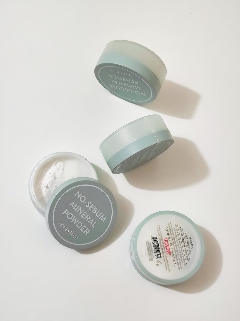 Flat lay of no-sebum mineral powder containers on a clean, white background.