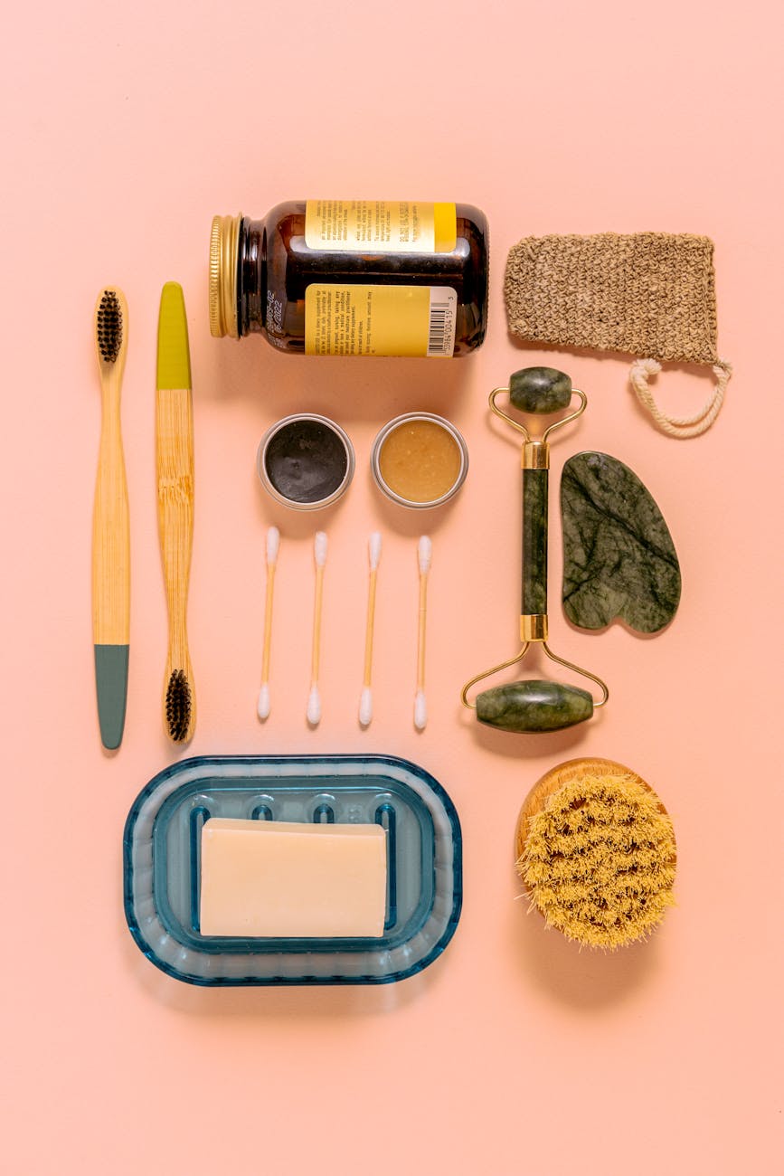 Flat lay of sustainable skincare items on pink background.