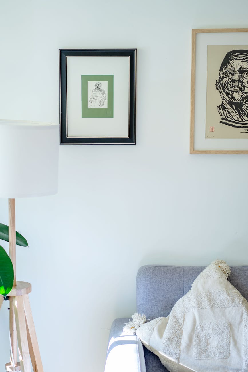 A bright, minimalist living room showcasing framed art and a cosy sofa.