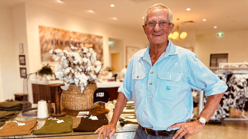 An older man standing in a clothing store.