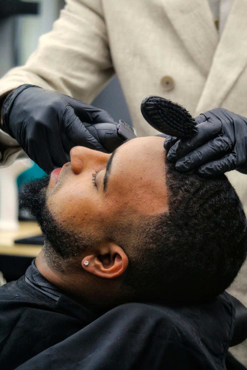 Close-up of a barber styling a client's hair in a modern salon setting, highlighting grooming techniques.