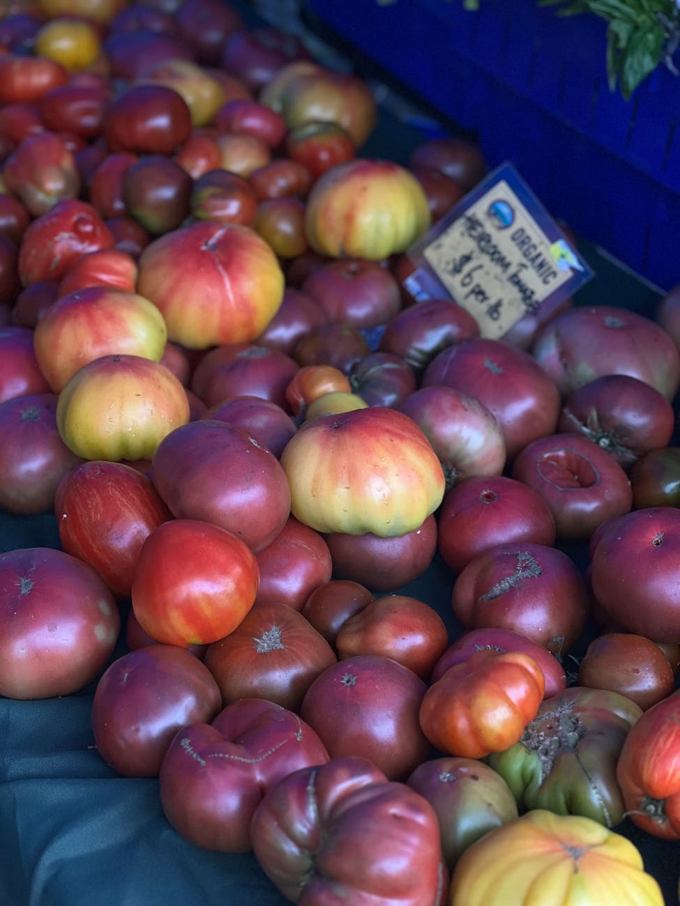 Baskets of heirloom tomatoes at a farmers' market stall