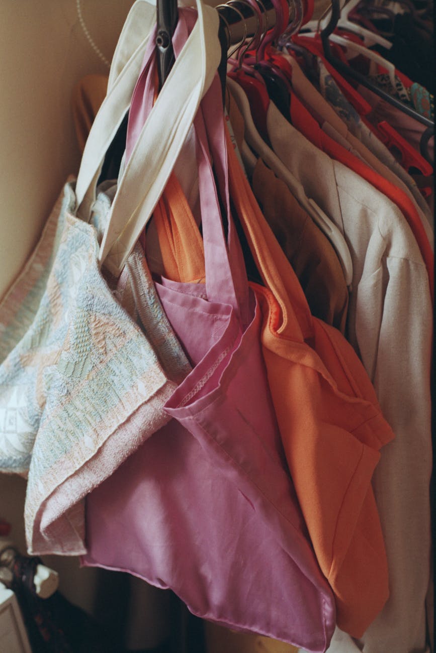 Designer clothes and bags hanging on a boutique rack, suggesting an archive wardrobe assembled for rental