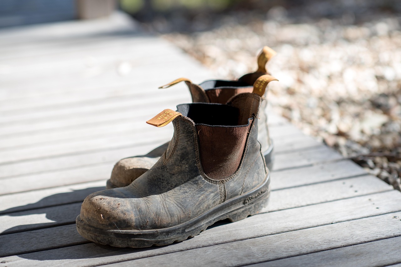 Worn Blundstone boots, scuffed and mud-caked, the leather holding the shape of the foot that broke them in.