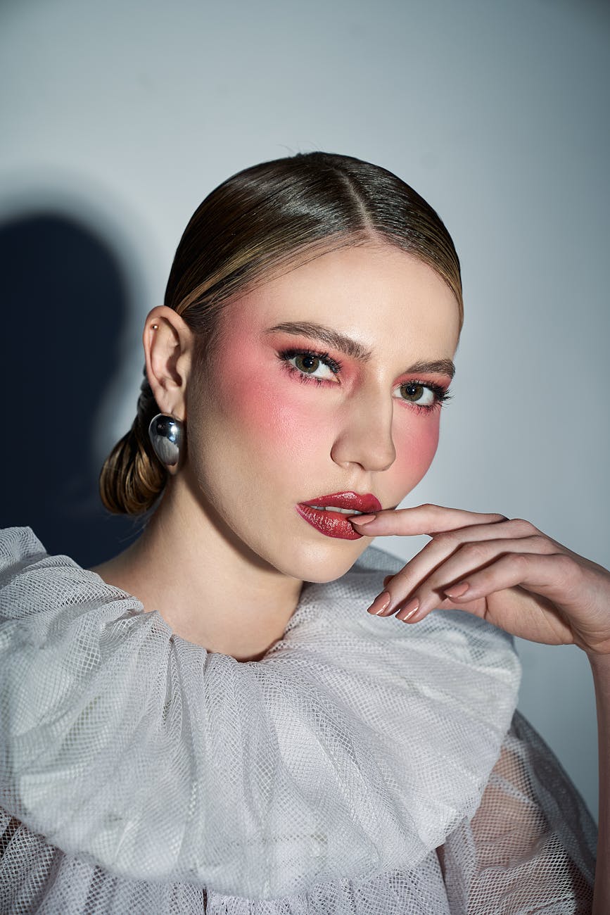 Close-up beauty portrait with a high flush across the cheeks and lips, echoing the return of red blush