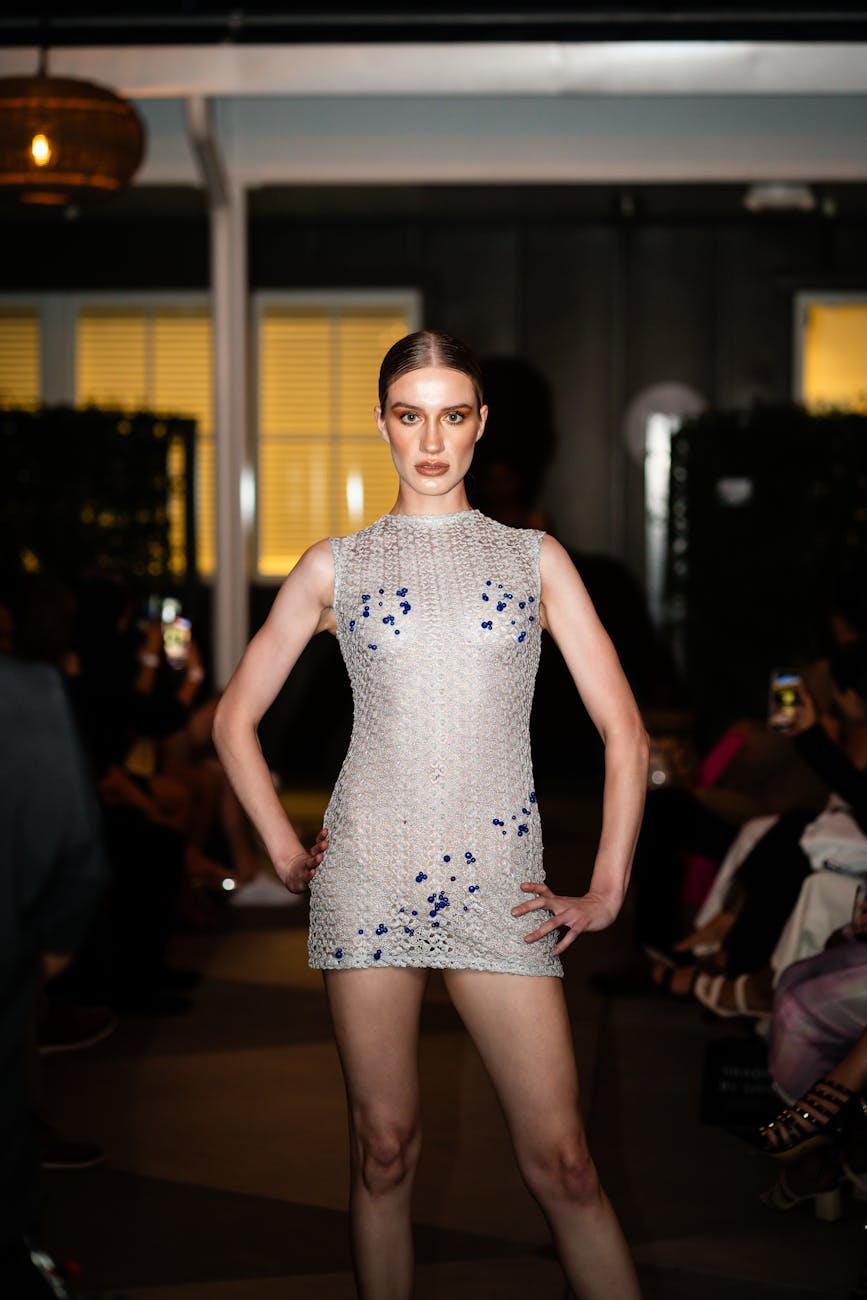 Runway model stepping through blue show lights at a fashion week presentation