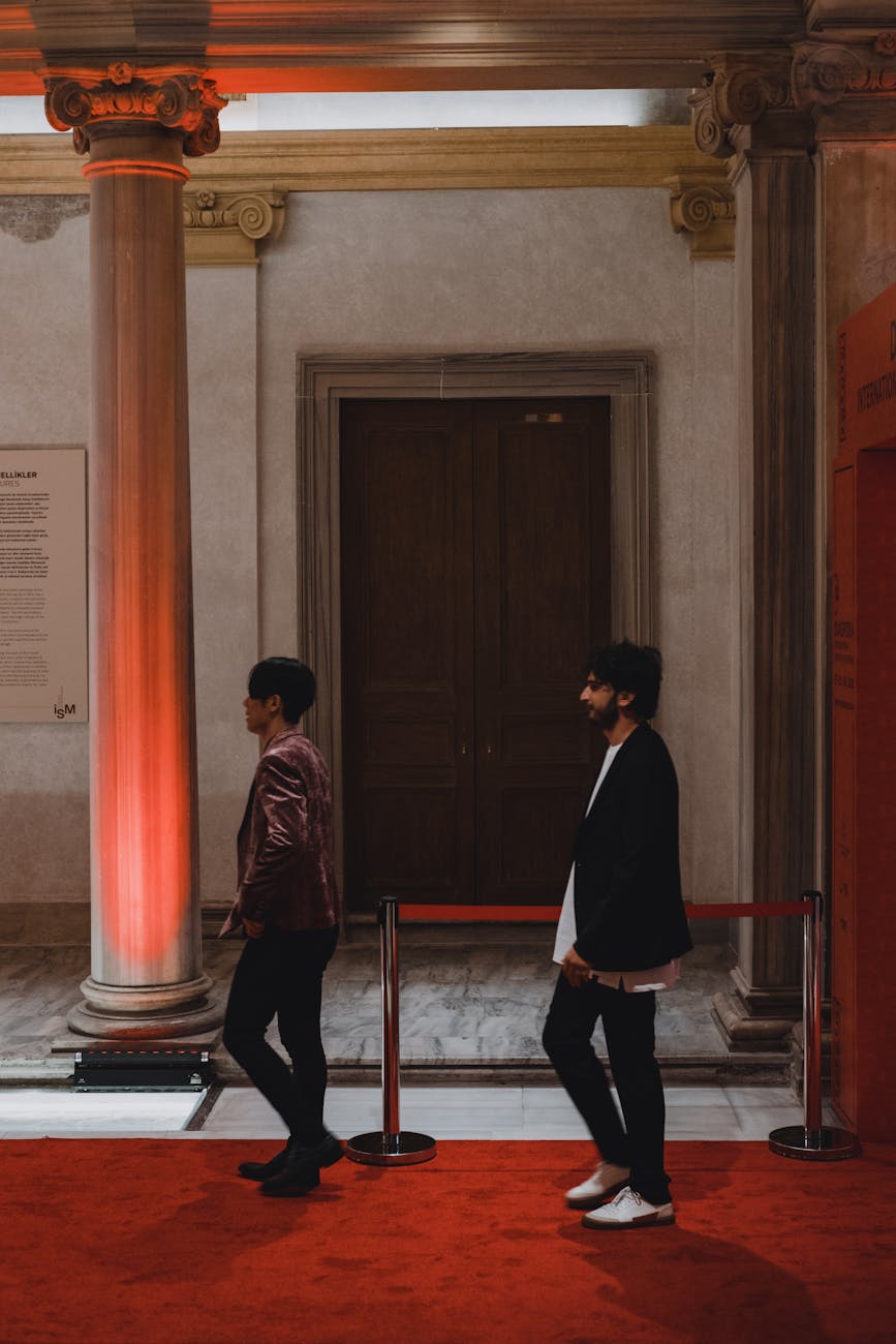 Guests walking a red carpet inside a grand museum staircase.