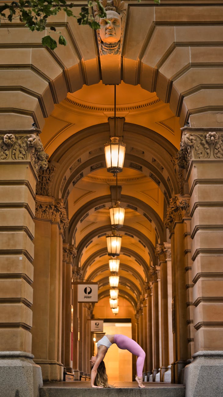 Woman practising yoga beneath Sydney's Martin Place archways
