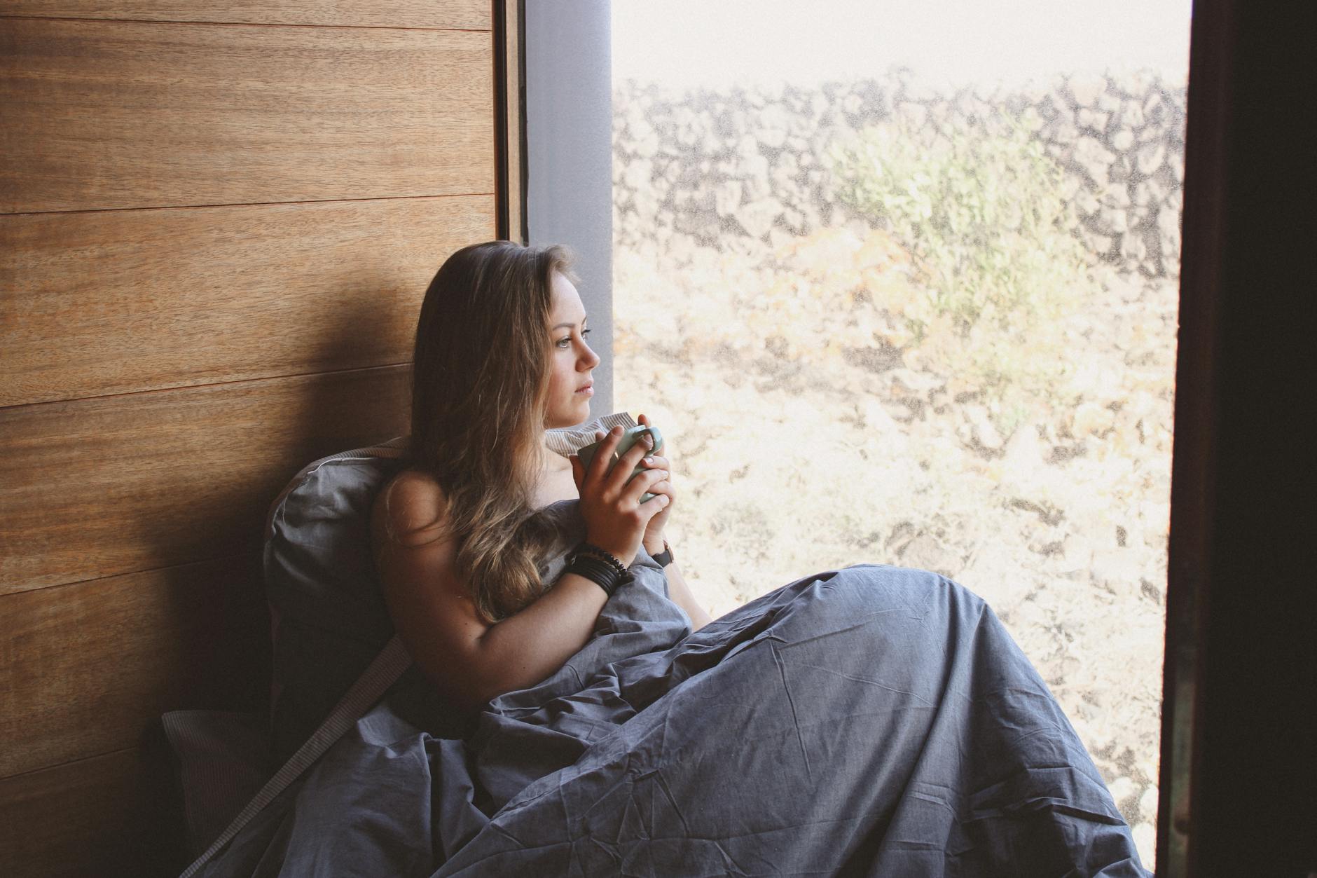 Person in distress seated on bed, used as hero image for anxiety study analysis