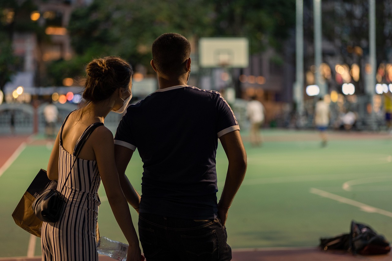 A couple walking through a city at night, the kind of ordinary date that now comes with a visible price tag.