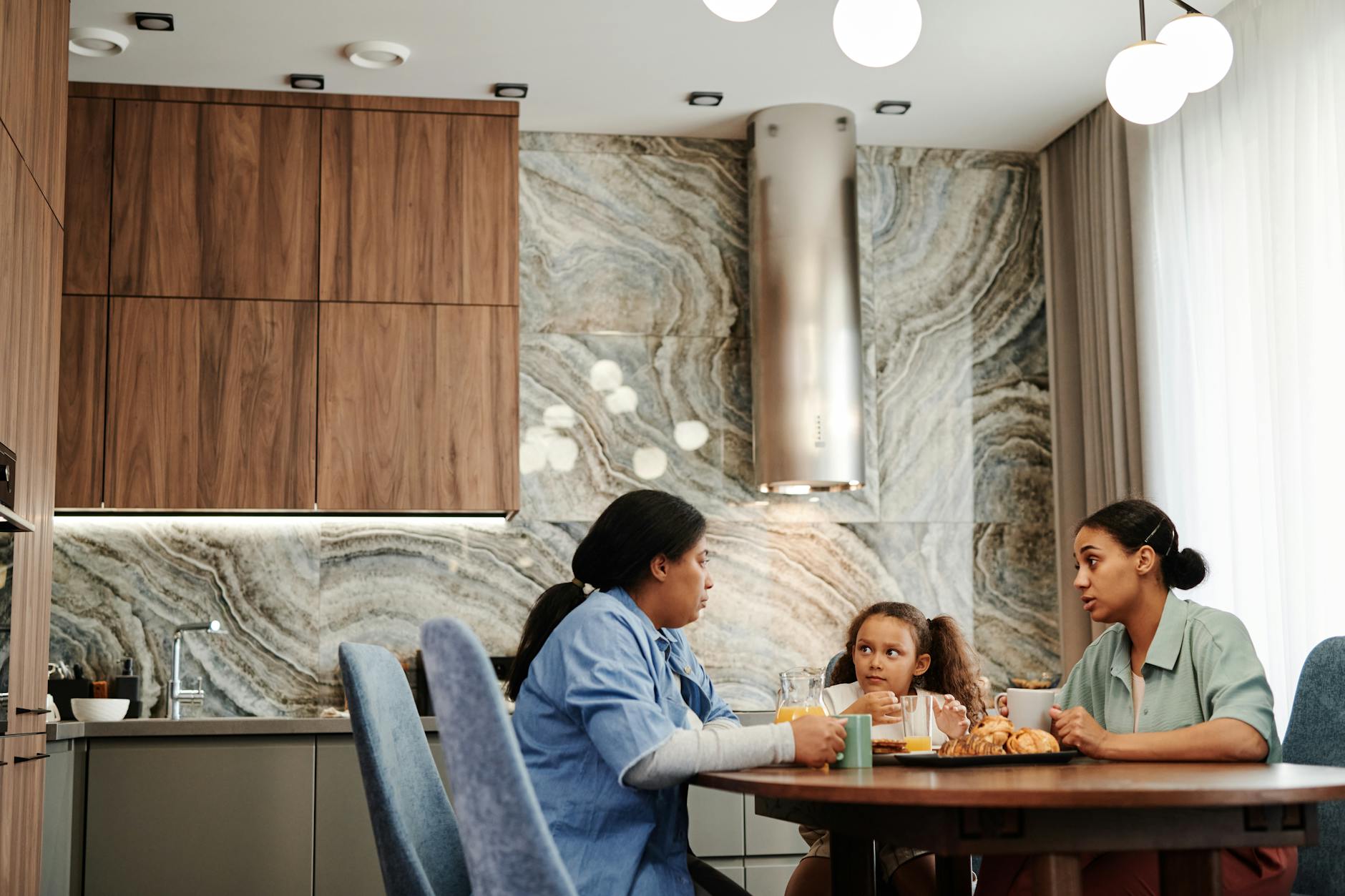 A mother and daughter sharing a quiet conversation at the kitchen table
