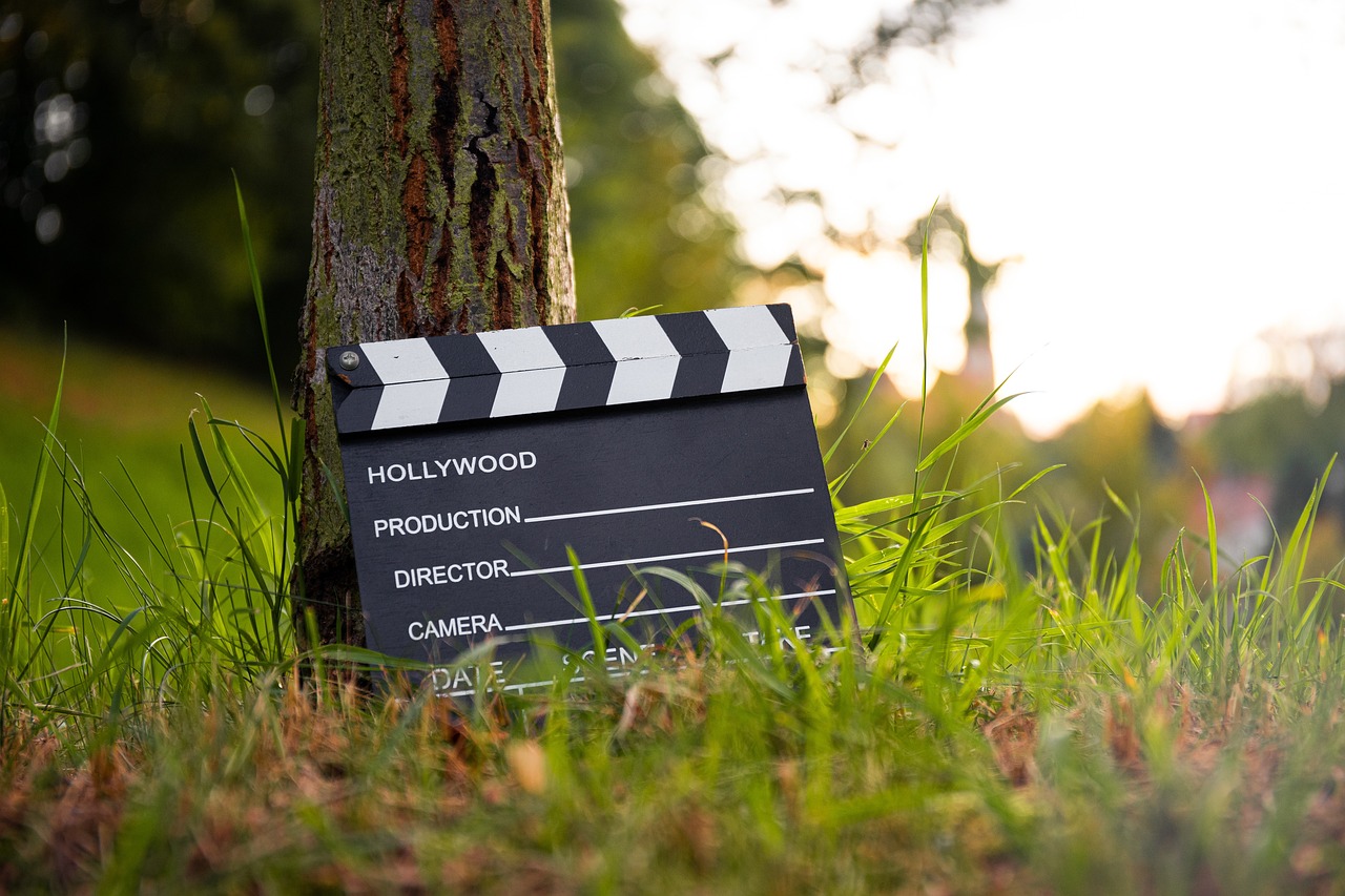 A clapperboard held against a dark film-set background