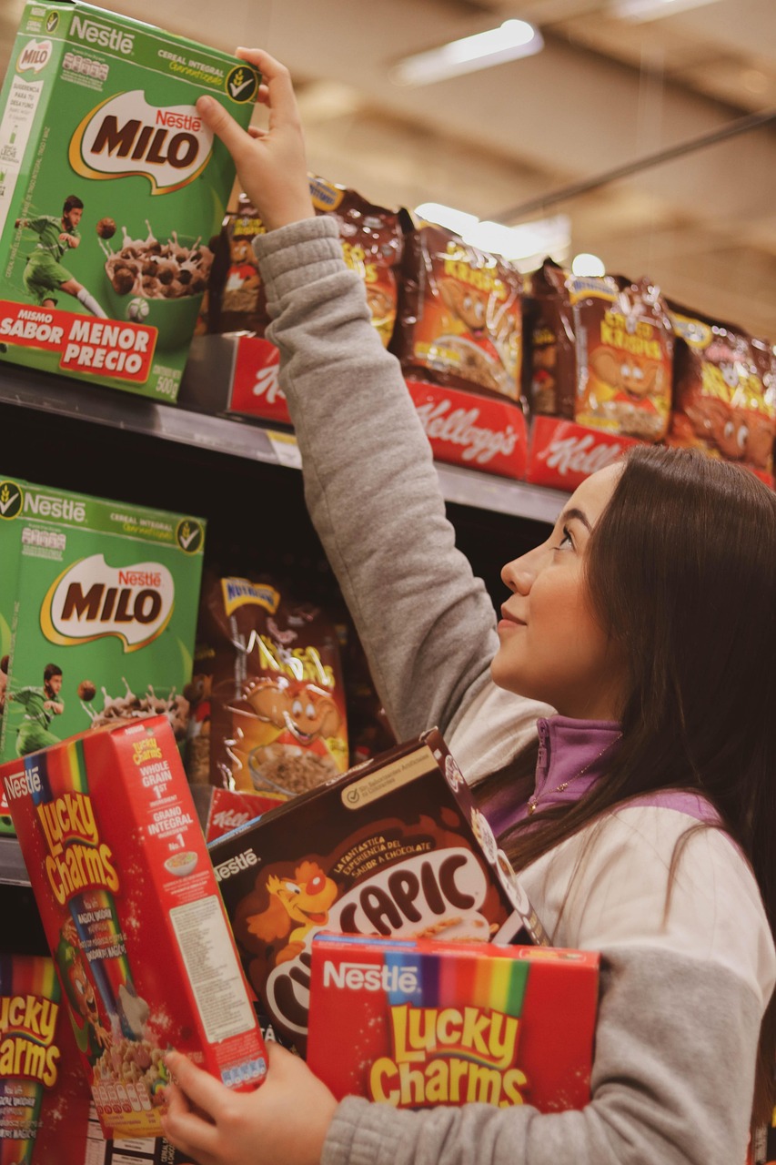 A shopper stands in a supermarket aisle surrounded by packaged foods.