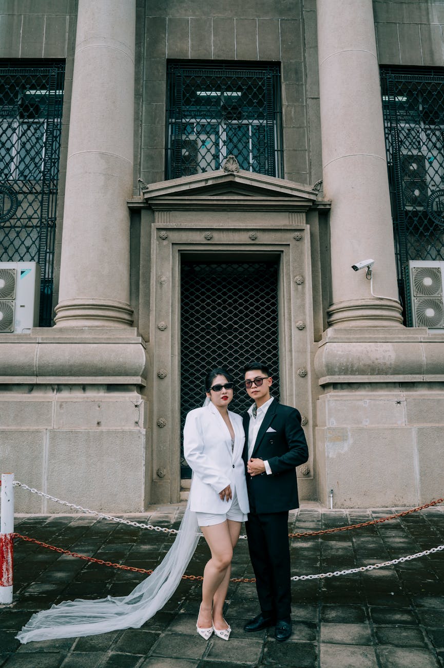 Tailored wedding couple outside a civic building with stone columns