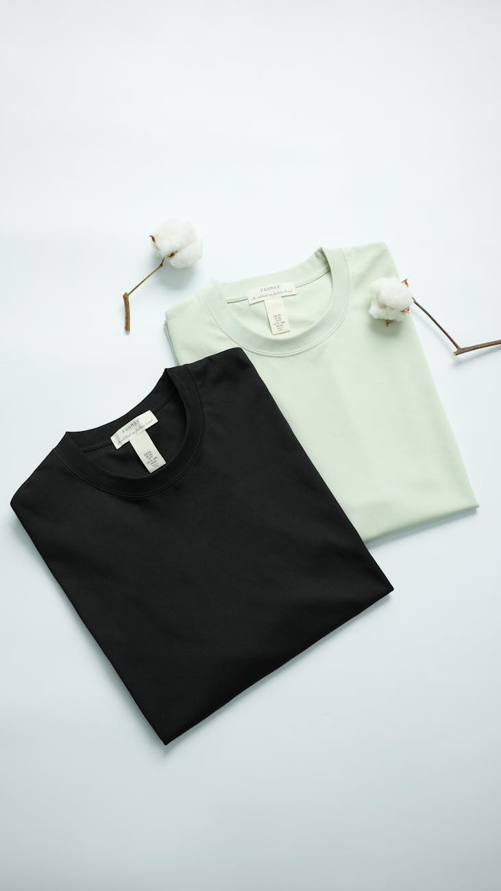 Folded cotton T-shirts with cotton stems, a quiet still life for an ethics-of-basics story