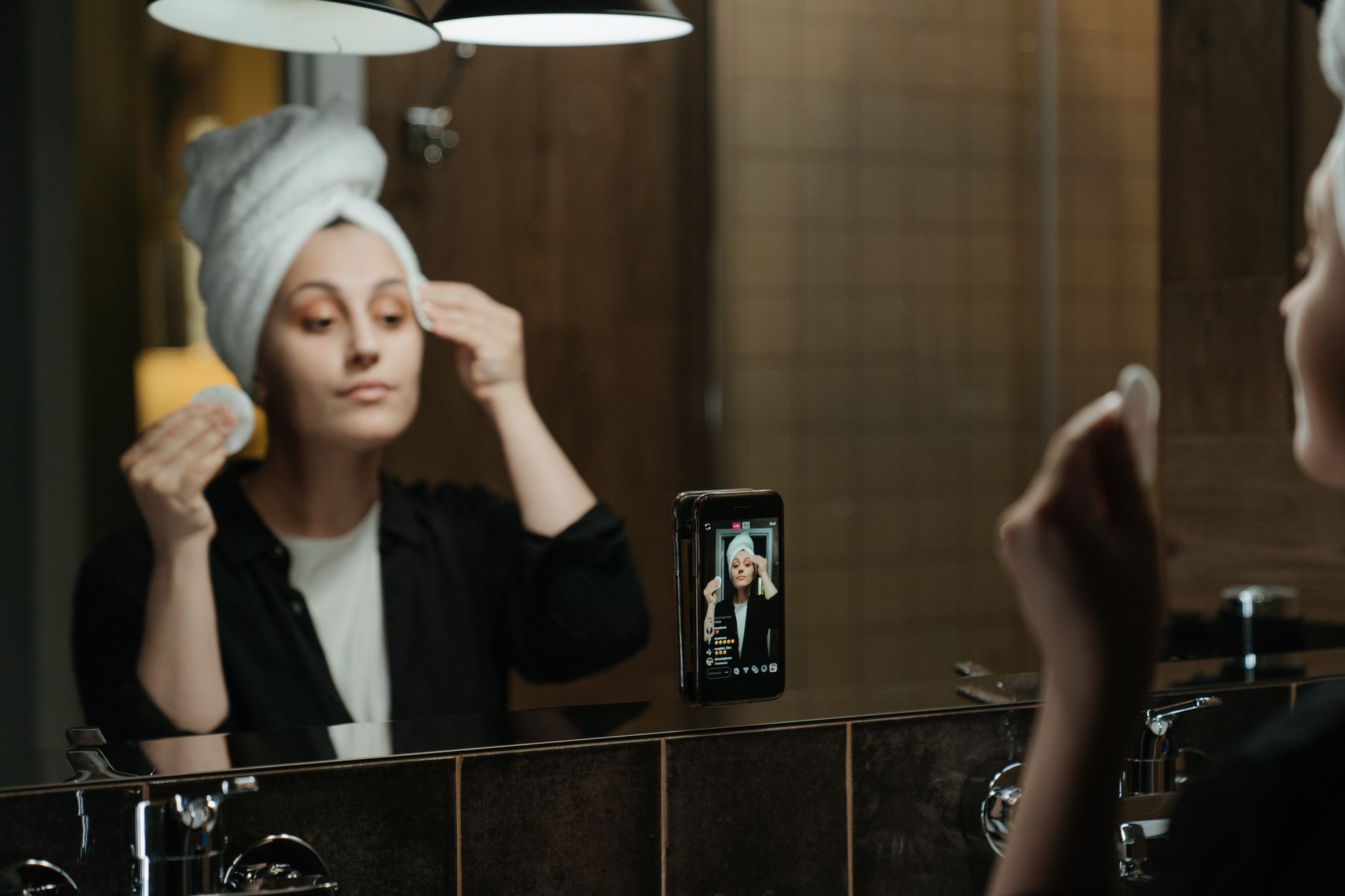 A skincare routine being filmed in a bathroom mirror