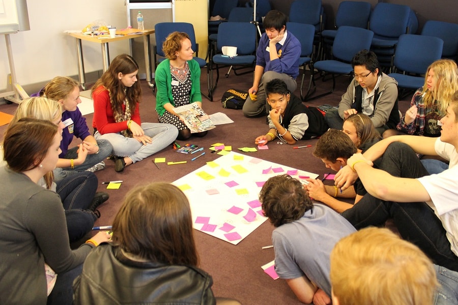 Group of students in a workshop with a teacher in a green sweater