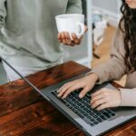 Woman In Brown Long Sleeve Shirt Using Macbook Pro